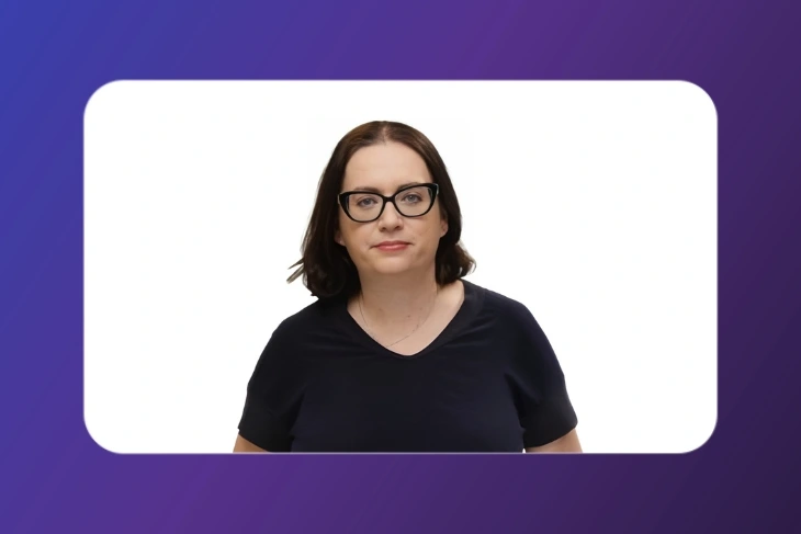 Portrait of a woman with dark hair and glasses, wearing a black top, centered inside a white rounded-rectangle frame on a purple gradient background.