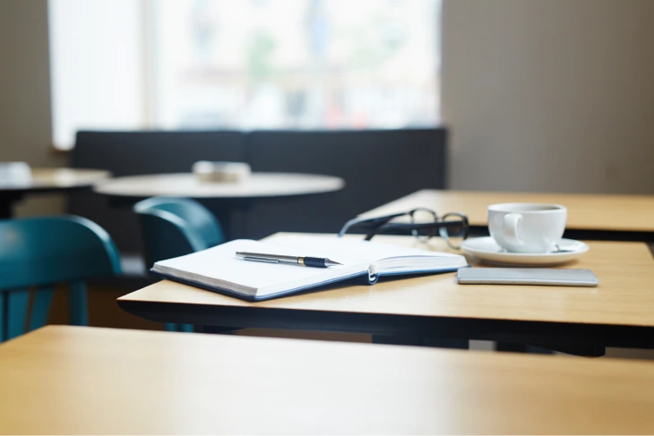 Desk with notebook and coffee illustrating a free AI training course