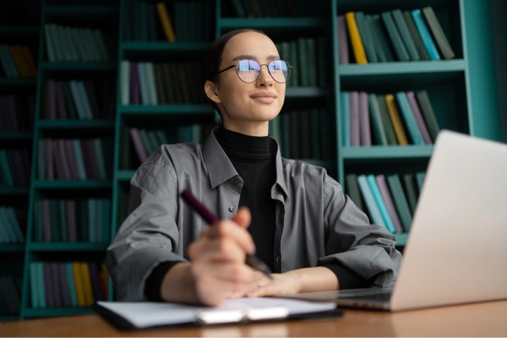 Why AI Literacy Is Important Person using a laptop and taking notes, illustrating why AI literacy is important for critical thinking, responsible AI use and digital decision-making.